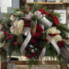 Large red and white floral arrangement with silver ribbon accents
