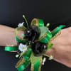 Green ribbon wrist corsage with small black and white flowers