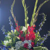 Tall red, white, and blue floral arrangement in a white vase