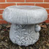 Gray mushroom-shaped garden stool with floral relief details