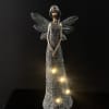 Decorative angel figurine with glowing lights on a dark background