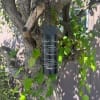 Black memorial wind chime hanging from a tree branch