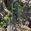 Black metal wind chime with Amazing Grace inscription hanging from a tree outdoors