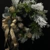 Holiday wreath with silver accents, gold ribbon, and dark greenery