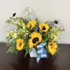 Sunflower arrangement in a white square vase with a blue ribbon