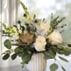 White roses and snapdragons in a ribbed vase with eucalyptus and succulents