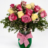 Pink and yellow roses in a green vase with a pink bow