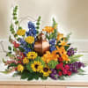 Colorful floral arrangement around a copper urn