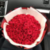 Large bouquet of red roses wrapped in white and red paper