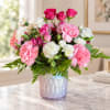 Pink and white carnations with roses in an iridescent vase