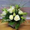 White roses and lilies arranged in a square vase