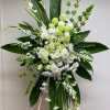 Tall white and green floral standing arrangement on an easel