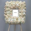 Floral photo frame covered in white and blush orchids on an easel