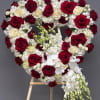 Heart-shaped floral arrangement of red and white roses on an easel
