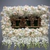 Large white floral standing arrangement on an easel with a central sign