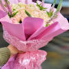 Pink bouquet of pale roses wrapped in pink paper with a heart ribbon