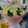Bouquet of pale yellow roses with white filler flowers and a white ribbon