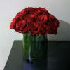 Red roses arranged in a clear glass vase