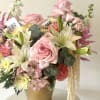 A lush garden-inspired arrangement featuring soft pink roses, delicate spray roses, elegant