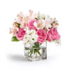 Pink roses and white flowers arranged in a clear square vase