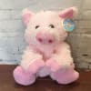 Pink plush pig toy with a tag attached