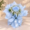 Blue rose bouquet wrapped in pale blue paper with white filler flowers