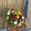 Bouquet of red roses, sunflowers, and mixed mums in a rustic arrangement