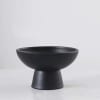 Black pedestal bowl vase on a white surface
