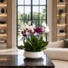 Potted orchids in white, pink, and purple blooms in a white bowl planter