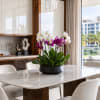 Potted orchid arrangement with white and purple blooms on a dining table