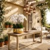 White orchids in a gold bowl on a wooden table in a patio setting