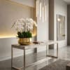 White orchid arrangement in a gold bowl on a console table