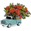Orange roses arranged in a turquoise pickup truck container