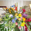 Large tropical flower arrangement with bright mixed blooms and broad leaves