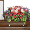 Colorful floral arrangement on a casket with red, white, and purple flowers