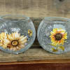 Four crackled glass bowls with painted floral designs on a wooden shelf