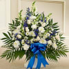 White and blue funeral spray with a blue ribbon