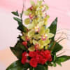 Red roses and yellow orchids in a glass vase