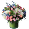 Mixed bouquet of pink, white, and purple flowers in a green glass vase