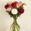 Mixed dahlias in pink, white, and red arranged in a clear glass vase