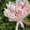 Bouquet of pale pink roses with pink spike flowers in white wrapping