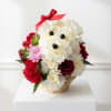 Flower arrangement shaped like a teddy bear in a wicker basket with a red bow