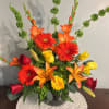 Mixed bouquet with red and yellow roses, orange lilies, and gerbera daisies in a vase