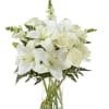 White lilies and roses arranged in a clear glass vase