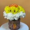 Yellow and white flowers with an orange rose in a rustic vase