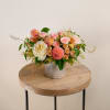 Peach and pink rose arrangement in a patterned ceramic vase