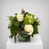 White roses and green chrysanthemums in a square glass vase