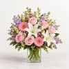 Pink roses, white lilies, and gerbera daisies in a clear glass vase