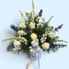 White roses and blue-white snapdragons in a vase with a ribbon