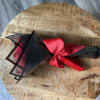 Wrapped bouquet tied with a red satin ribbon